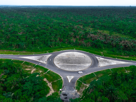 Aerial view of a roundabout on a road surrounded by dense tropical forest on Bonny Island in Bonny Rivers Nigeria.