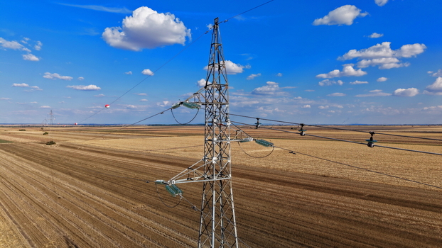 Aerial view of a high voltage transmission tower with signal balls for marking power lines in a rural field in Bavaniste Vojvodina Serbia. Aerial view of a high voltage transmission tower with signal balls for marking power lines in a rural field in Bavaniste Vojvodina Serbia.