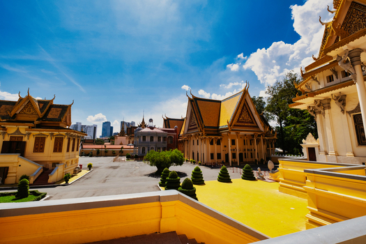 View of the ornate traditional Khmer architecture of the Royal Palace of Cambodia with its iconic yellow roofs under a bright blue sky in Phnom Penh Phnom Penh Cambodia. View of the ornate traditional Khmer architecture of the Royal Palace of Cambodia with its iconic yellow roofs under a bright blue sky in Phnom Penh Phnom Penh Cambodia.