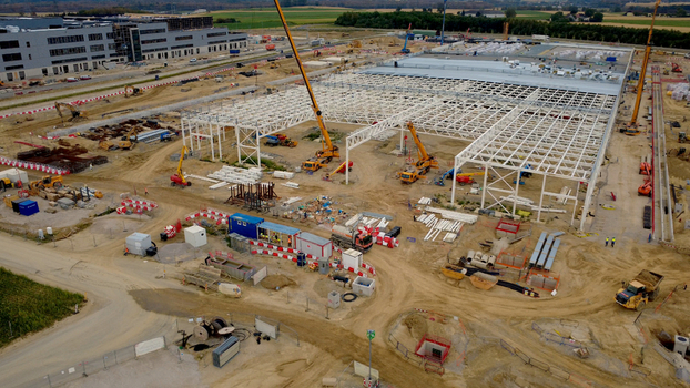 Aerial view of a large data center construction site featuring a steel frame structure multiple cranes heavy machinery and earthworks in Kronstorf Upper Austria Austria.