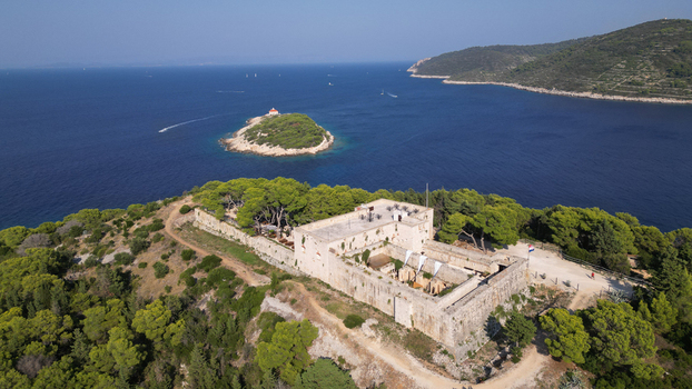Aerial view of Fort George on a lush green hill overlooking the Adriatic Sea and a small island Vis Splitsko dalmatinska Croatia. Aerial view of Fort George on a lush green hill overlooking the Adriatic Sea and a small island Vis Splitsko dalmatinska Croatia.