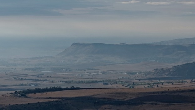 Aerial view of the rugged landscape with mesas rolling hills and a winding road through the dry valley in Golden Colorado United States.