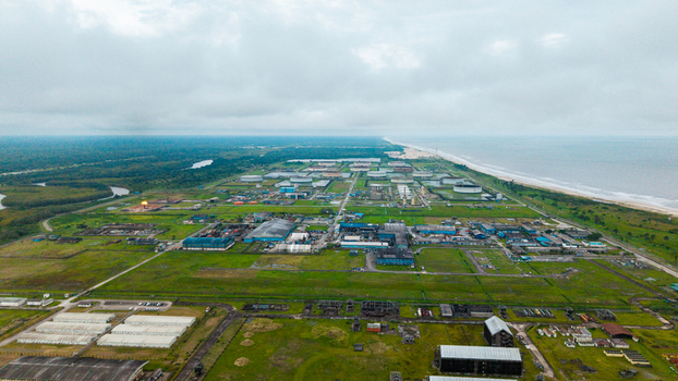 Aerial view of the industrial oil and gas facility near Ibeno Beach featuring storage tanks processing units and pipelines set against the coastline in Kwa Ibo Akwa Ibom Nigeria.