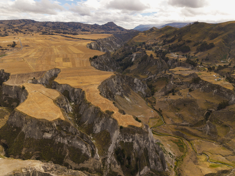 Aerial view of Toachi River Canyon featuring deep rocky gorges golden agricultural fields and rugged terrain in Zumbahua Cotopaxi Ecuador. Aerial view of Toachi River Canyon featuring deep rocky gorges golden agricultural fields and rugged terrain in Zumbahua Cotopaxi Ecuador.