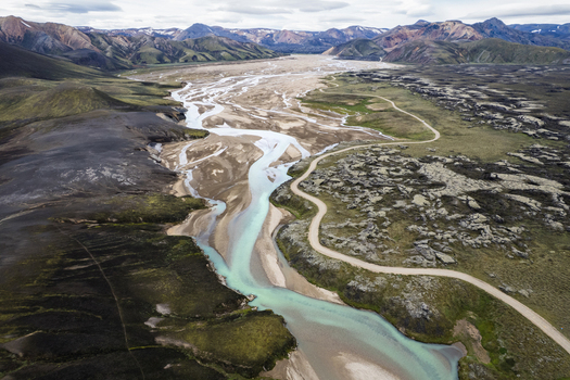 Aerial view of the braided glacial river and the winding F208 road through the volcanic mountain landscape in the Icelandic Highlands Iceland. Aerial view of the braided glacial river and the winding F208 road through the volcanic mountain landscape in the Icelandic Highlands Iceland.