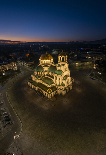 Aerial view of the illuminated Patriarchal Cathedral St. Alexander Nevsky at night surrounded by the city square and urban lights in Sofia Sofia City Province Bulgaria. Aerial view of the illuminated Patriarchal Cathedral St. Alexander Nevsky at night surrounded by the city square and urban lights in Sofia Sofia City Province Bulgaria.