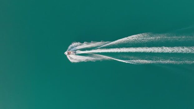 Aerial view of a motorboat cruising on turquoise water Italy. Aerial view of a motorboat cruising on turquoise water Italy.