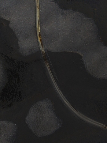 Aerial view of dark and light contrasts create a textured abstract landscape with a thin curved line cutting through the shadows Lakagigar Iceland. Aerial view of dark and light contrasts create a textured abstract landscape with a thin curved line cutting through the shadows Lakagigar Iceland.