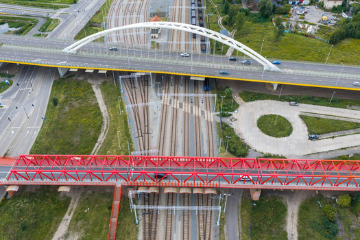 Aerial view of the historic red steel truss viaduct spanning over multiple railway tracks with a modern white arch bridge in the background in Gdansk Pomeranian Voivodeship Poland. Aerial view of the historic red steel truss viaduct spanning over multiple railway tracks with a modern white arch bridge in the background in Gdansk Pomeranian Voivodeship Poland.