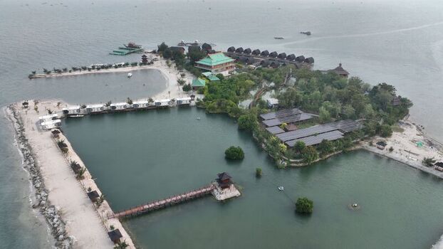 Aerial view of Pulau Lima Resort featuring overwater bungalows a wooden pier lush greenery and calm coastal waters in Kasemen Banten Indonesia. Aerial view of Pulau Lima Resort featuring overwater bungalows a wooden pier lush greenery and calm coastal waters in Kasemen Banten Indonesia.