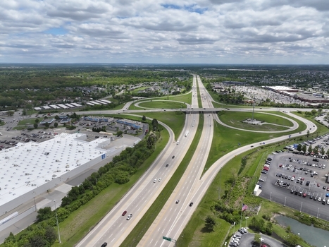 Aerial view of a highway interchange with cloverleaf ramps traffic and a large warehouse building under a cloudy sky in Columbus Ohio United States. Aerial view of a highway interchange with cloverleaf ramps traffic and a large warehouse building under a cloudy sky in Columbus Ohio United States.