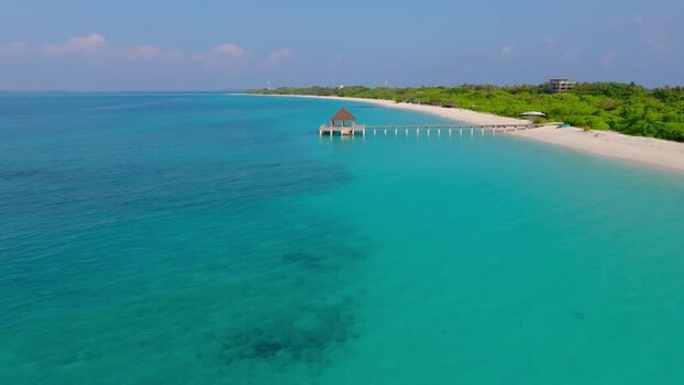 Aerial view of pier extending into turquoise water Maldives.