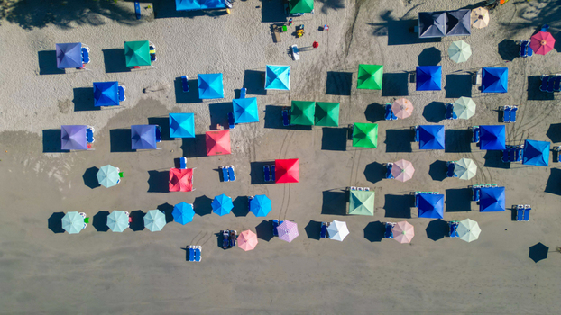 Aerial view of colorful beach umbrellas casting long shadows on the sandy shore Quepos Puntarenas Province Costa Rica. Aerial view of colorful beach umbrellas casting long shadows on the sandy shore Quepos Puntarenas Province Costa Rica.