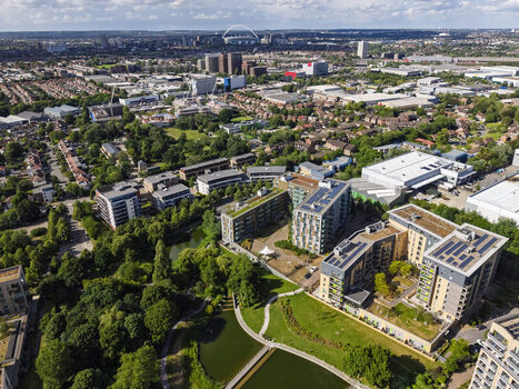 Aerial view of modern apartment buildings with green roofs and solar panels situated near a lake and parkland in the Park Royal area of London England United Kingdom. Aerial view of modern apartment buildings with green roofs and solar panels situated near a lake and parkland in the Park Royal area of London England United Kingdom.