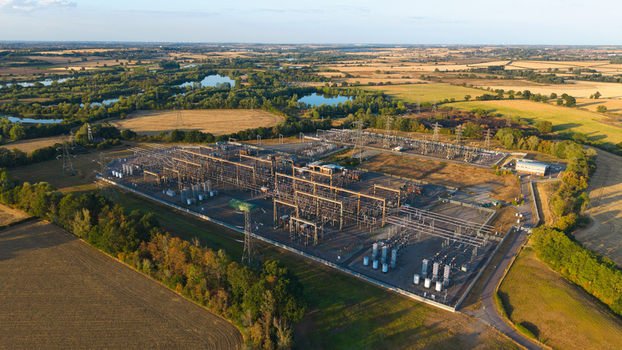 Aerial view of Grendon national grid station featuring electrical infrastructure power lines and transformers surrounded by rural fields trees and ponds in Northampton England United Kingdom. Aerial view of Grendon national grid station featuring electrical infrastructure power lines and transformers surrounded by rural fields trees and ponds in Northampton England United Kingdom.