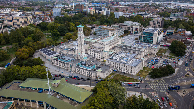 Aerial view of the Southampton Civic Centre with its prominent clock tower surrounded by historic stone buildings urban streets and lush green trees in Southampton England United Kingdom. Aerial view of the Southampton Civic Centre with its prominent clock tower surrounded by historic stone buildings urban streets and lush green trees in Southampton England United Kingdom.