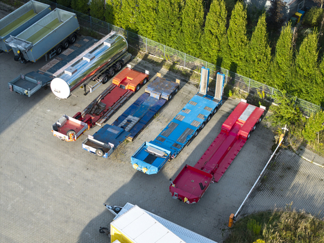 Aerial view of various flatbed trailers and a tanker trailer parked in a paved lot in Krakow Lesser Poland Voivode Poland. Aerial view of various flatbed trailers and a tanker trailer parked in a paved lot in Krakow Lesser Poland Voivode Poland.