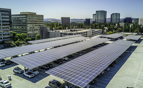 Aerial view of solar panel carports covering a parking lot at Topanga Village with surrounding office buildings in Los Angeles California United States.