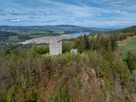 Aerial view of the historic ruins of Burg Montsalvens surrounded by dense forest overlooking the scenic landscape and lake near Broc Fribourg Switzerland. Aerial view of the historic ruins of Burg Montsalvens surrounded by dense forest overlooking the scenic landscape and lake near Broc Fribourg Switzerland.