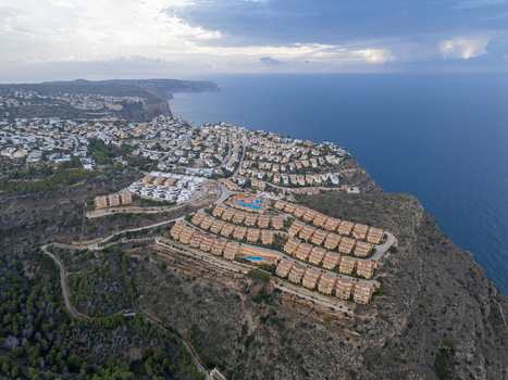 Aerial view of residential villas and swimming pools on a cliff overlooking the Mediterranean Sea in Moraira Valencian Community Spain.