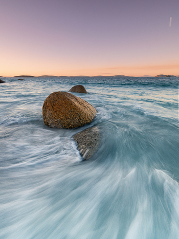 View of large granite boulders in the surf at sunset in Frenchman Bay Western Australia Australia. View of large granite boulders in the surf at sunset in Frenchman Bay Western Australia Australia.