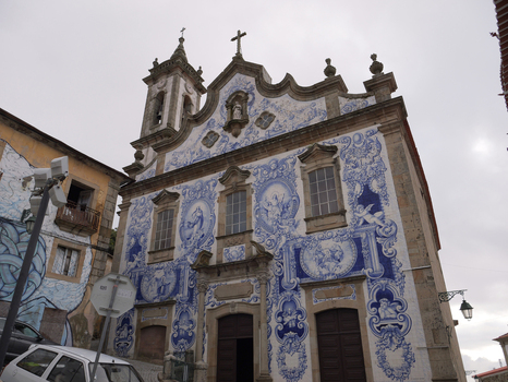 View of the Church of Santa Maria Maior with its intricate blue and white azulejo tile facade and stone architectural details in Covilha Castelo Branco Portugal. View of the Church of Santa Maria Maior with its intricate blue and white azulejo tile facade and stone architectural details in Covilha Castelo Branco Portugal.