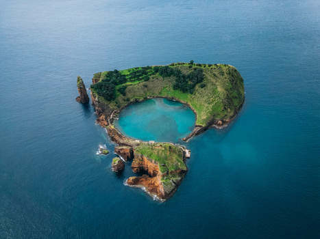 Aerial view of a vibrant islet with a turquoise lagoon embraced by emerald slopes juxtaposed against the deep blue sea Vila Franca do Campo Azores Portugal.