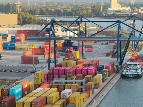 Genk Belgium 27 August 2026 Aerial view of Haven Genk container terminal with stacks of colorful shipping containers gantry cranes and a cargo ship docked at the waterfront. Genk Belgium 27 August 2026 Aerial view of Haven Genk container terminal with stacks of colorful shipping containers gantry cranes and a cargo ship docked at the waterfront.