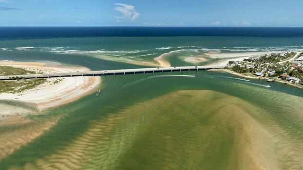Aerial view of Matanzas Inlet showing the bridge spanning the waterway sandbars and coastal landscape in St. Johns County Florida United States. Aerial view of Matanzas Inlet showing the bridge spanning the waterway sandbars and coastal landscape in St. Johns County Florida United States.
