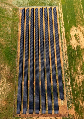 Aerial view of a large solar panel array set within a rural field showcasing rows of photovoltaic modules capturing sunlight for renewable energy production in Ladismith Western Cape South Africa. Aerial view of a large solar panel array set within a rural field showcasing rows of photovoltaic modules capturing sunlight for renewable energy production in Ladismith Western Cape South Africa.