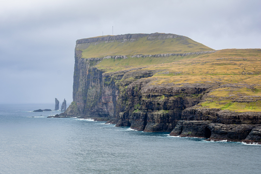 View of the dramatic sea cliffs and rocky coastline of the Faroe Islands.