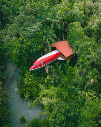 Aerial view of the 727 Fuselage Home nestled within the lush tropical rainforest canopy in Costa Rica.