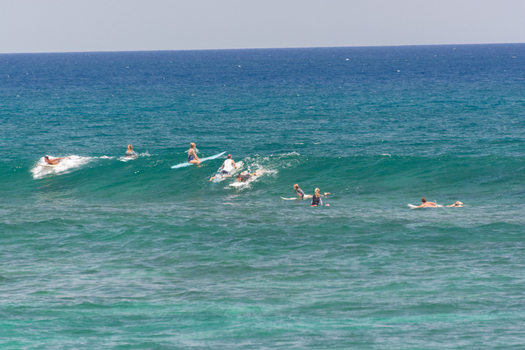 View of surfers riding waves in the ocean in Maui County Hawaii United States.