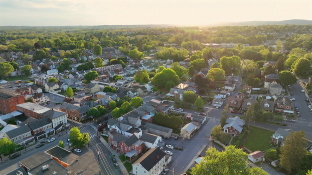 Aerial view of the residential neighborhood with lush green trees and houses illuminated by the warm light of the golden hour in Ephrata Pennsylvania United States. Aerial view of the residential neighborhood with lush green trees and houses illuminated by the warm light of the golden hour in Ephrata Pennsylvania United States.