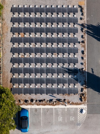 Aerial view of a solar panel array installed above a parking area with an electric vehicle charging station in Cascais Lisboa Portugal. Aerial view of a solar panel array installed above a parking area with an electric vehicle charging station in Cascais Lisboa Portugal.
