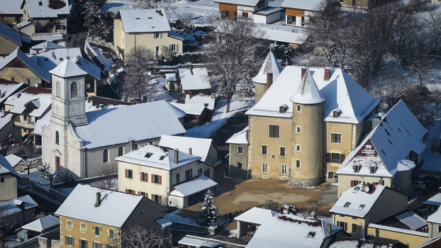 Aerial view of the historic Vesancy castle and church surrounded by snow covered rooftops and winter trees in Vesancy Auvergne Rhone Alpes France. Aerial view of the historic Vesancy castle and church surrounded by snow covered rooftops and winter trees in Vesancy Auvergne Rhone Alpes France.