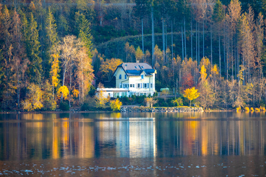 View of a charming house nestled among vibrant autumn foliage on the edge of a serene lake with clear reflections Breitnau Baden Wurttemberg Germany. View of a charming house nestled among vibrant autumn foliage on the edge of a serene lake with clear reflections Breitnau Baden Wurttemberg Germany.