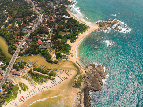 Aerial view of the tropical coastline featuring turquoise ocean waves sandy beaches and traditional fishing boats near the coastal road in Dodanduwa Southern Province Sri Lanka. Aerial view of the tropical coastline featuring turquoise ocean waves sandy beaches and traditional fishing boats near the coastal road in Dodanduwa Southern Province Sri Lanka.