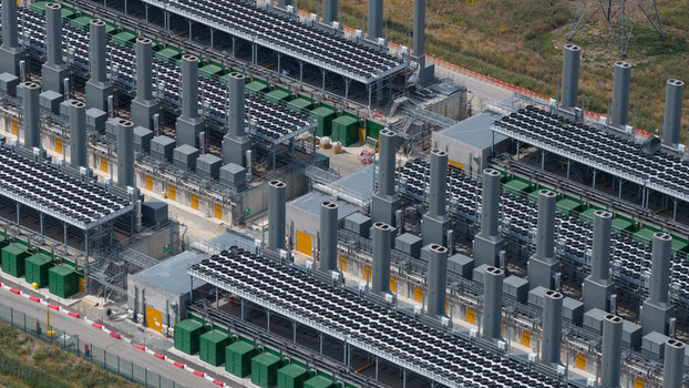 Aerial view of Thurrock Flexible Generation Substation featuring rows of industrial power generation units cooling fans and tall exhaust stacks in Tilbury England United Kingdom.