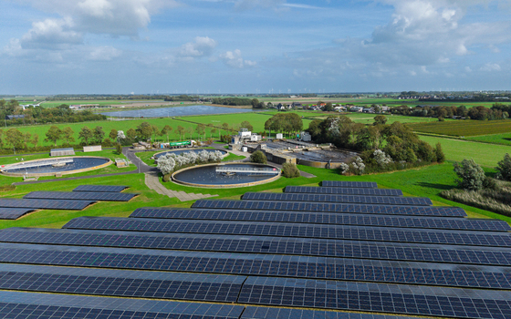 Aerial view of a water treatment plant featuring circular sedimentation tanks and a large solar panel array situated in the green landscape of Schagerbrug Noord Holland Netherlands. Aerial view of a water treatment plant featuring circular sedimentation tanks and a large solar panel array situated in the green landscape of Schagerbrug Noord Holland Netherlands.