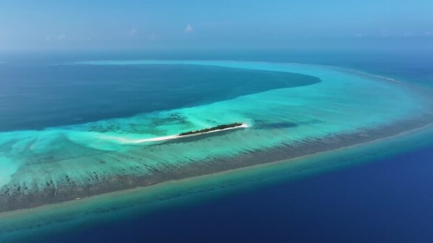 Aerial view of a tropical island and coral reef Maldives.