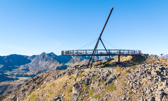 Aerial view of Tristaina Sundial Balcony a circular viewing platform on a mountain peak surrounded by rugged rocky terrain and distant mountains in Ordino Ordino Andorra.