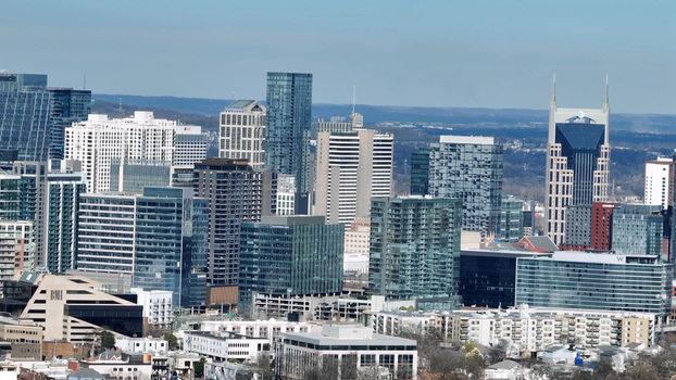 Aerial view of the Nashville skyline featuring modern skyscrapers glass office buildings and the iconic ATT Building under a clear blue sky in Nashville Tennessee United States.