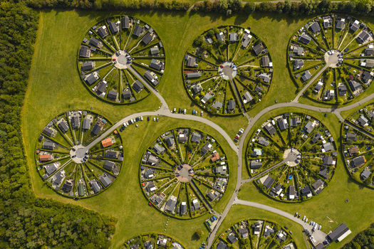 Aerial view of Haveforeningen Harekaer circular allotment gardens with houses arranged in spokes around central hubs and lush green lawns in Brondby Denmark. Aerial view of Haveforeningen Harekaer circular allotment gardens with houses arranged in spokes around central hubs and lush green lawns in Brondby Denmark.
