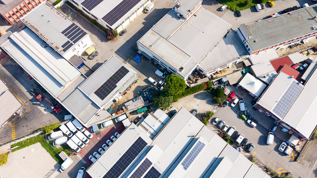 Aerial view of industrial district with manufacturing facilities warehouses and parked vehicles in Milan Lombardy Italy.