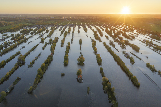 Aerial view of Scheendijk featuring narrow strips of land and trees surrounded by water at sunset with golden light reflecting on the surface in Breukelen Utrecht Netherlands. Aerial view of Scheendijk featuring narrow strips of land and trees surrounded by water at sunset with golden light reflecting on the surface in Breukelen Utrecht Netherlands.
