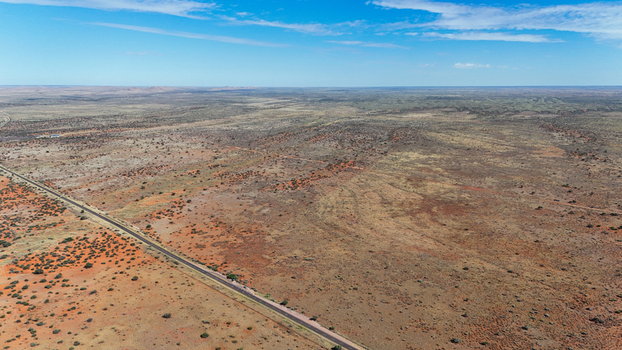 Aerial view of a solitary road cutting through the arid landscape where ochre earth meets the vast blue sky Karoo Desert Northern Cape South Africa. Aerial view of a solitary road cutting through the arid landscape where ochre earth meets the vast blue sky Karoo Desert Northern Cape South Africa.
