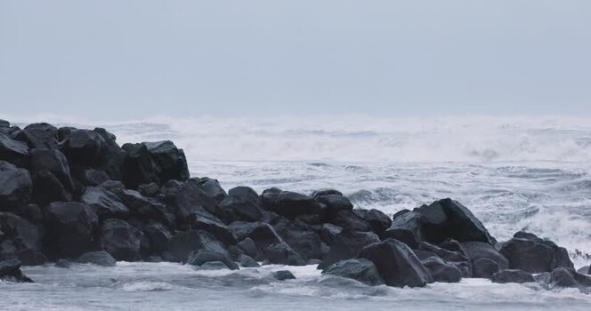 View of dark volcanic rocks on the coast in Iceland. View of dark volcanic rocks on the coast in Iceland.
