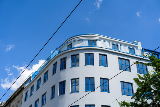 View of a modern white building with blue window frames and a curved facade under a clear blue sky in Bratislava Bratislava Region Slovakia. View of a modern white building with blue window frames and a curved facade under a clear blue sky in Bratislava Bratislava Region Slovakia.