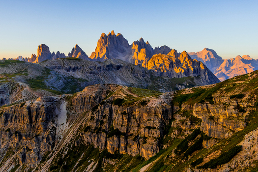 View of the rugged rocky peaks of the Auronzo Dolomites illuminated by the warm golden hour light in the mountain landscape of Auronzo Veneto Italy.